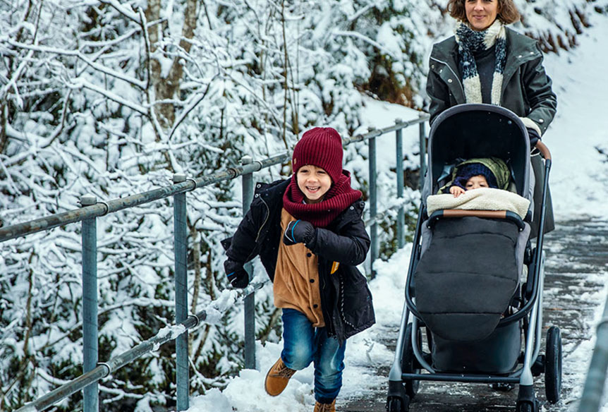 A family taking a winter walk with a stroller